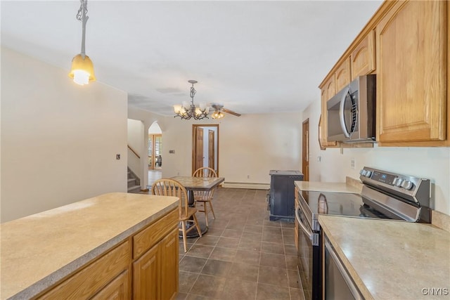 kitchen featuring hanging light fixtures, arched walkways, stainless steel appliances, and light countertops