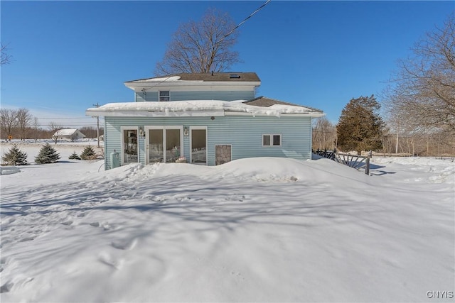 view of snow covered back of property