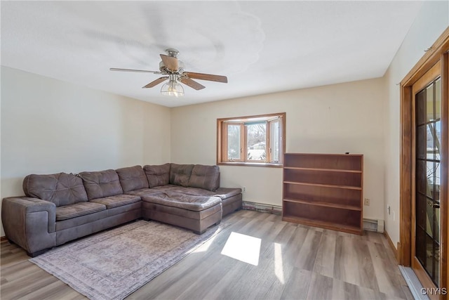 living area with a baseboard radiator, ceiling fan, and wood finished floors