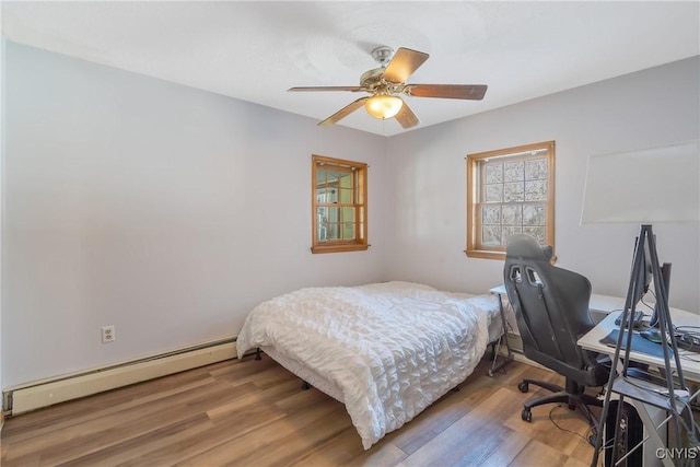 bedroom with a baseboard radiator, ceiling fan, and wood finished floors