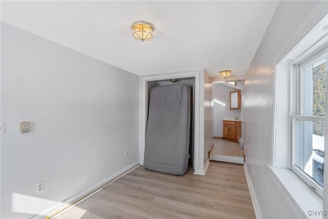 unfurnished bedroom featuring light wood-type flooring and baseboards