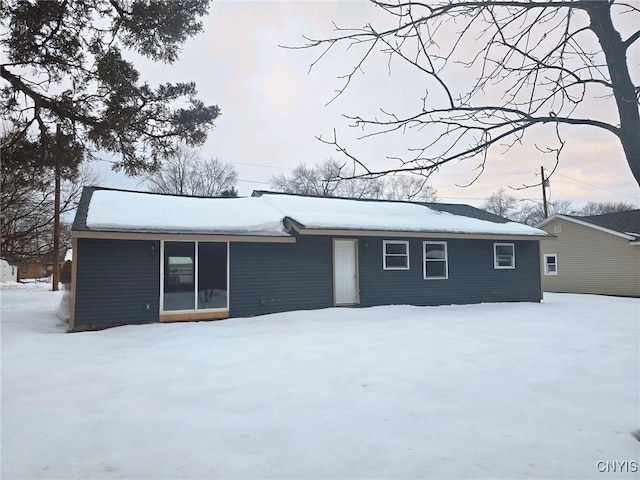 view of snow covered back of property