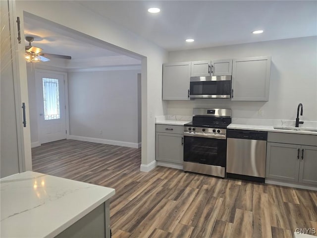 kitchen featuring dark wood-style floors, stainless steel appliances, a sink, and gray cabinetry