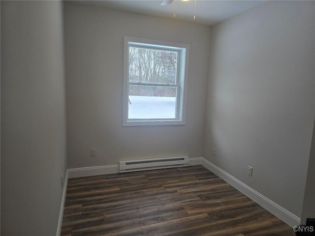 unfurnished room featuring a baseboard heating unit, dark wood-style flooring, baseboards, and a ceiling fan