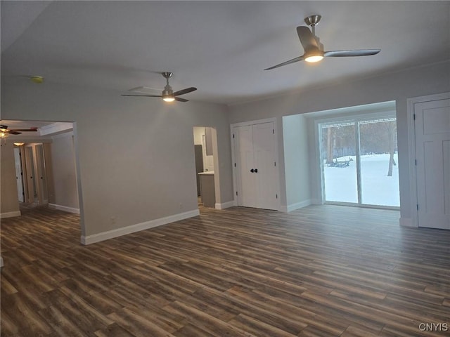 unfurnished living room featuring dark wood-style flooring, a ceiling fan, and baseboards