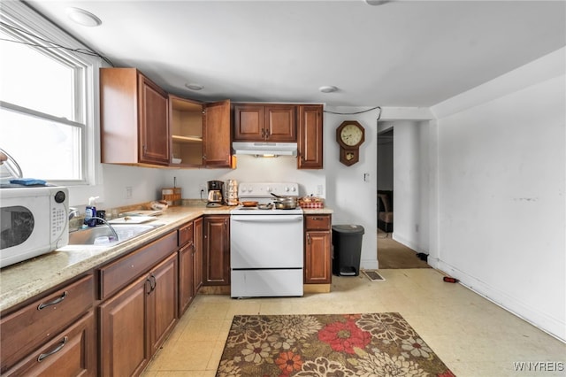 kitchen with under cabinet range hood, white appliances, a sink, light countertops, and open shelves