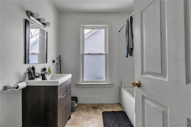 full bathroom featuring baseboards, a bathtub, and vanity