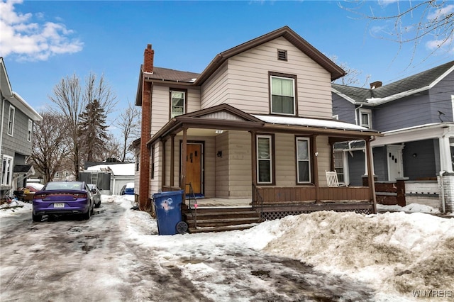 view of front of home featuring a chimney and a porch