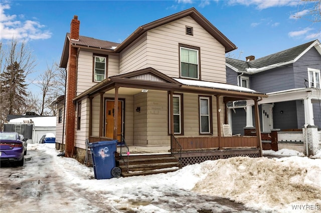 view of front of home with a chimney and a porch