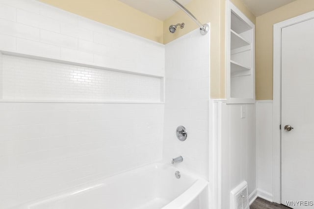 full bath featuring shower / washtub combination, wainscoting, and visible vents