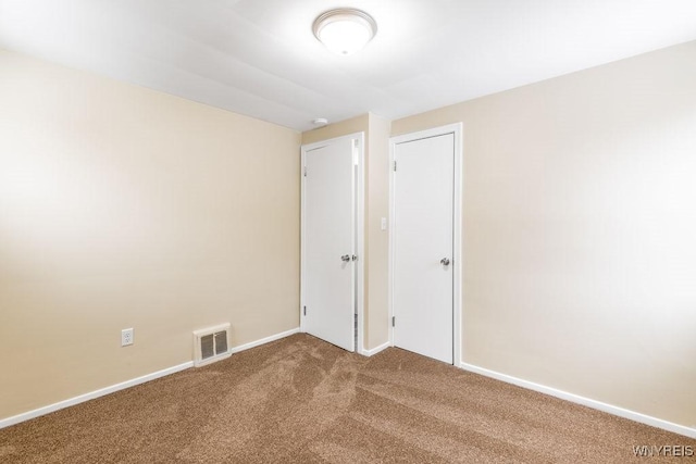 unfurnished room featuring carpet floors, baseboards, and visible vents