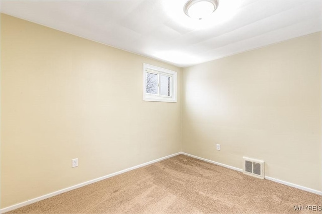 unfurnished room with visible vents, light carpet, and baseboards