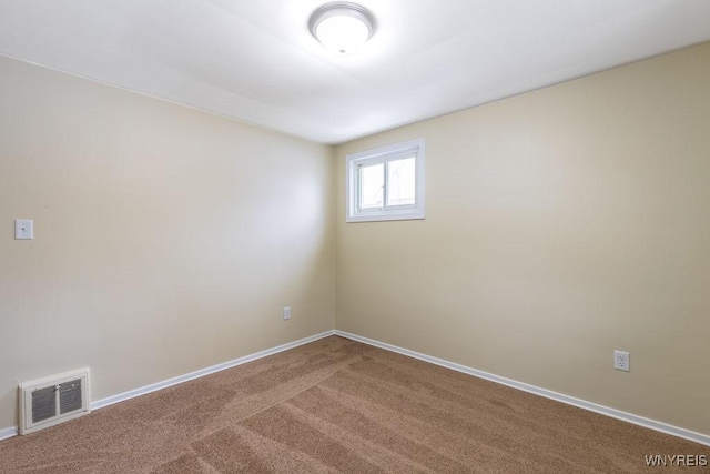 carpeted spare room with visible vents and baseboards