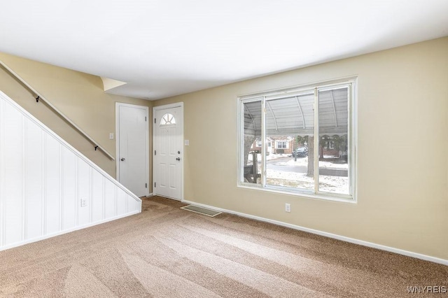 foyer entrance featuring carpet, visible vents, stairway, and baseboards