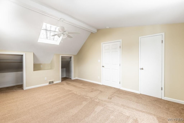 bonus room with visible vents, baseboards, a ceiling fan, lofted ceiling with skylight, and carpet flooring