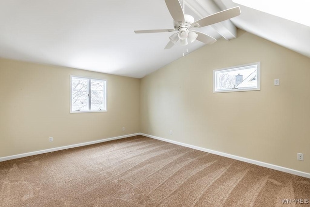 unfurnished room featuring vaulted ceiling with beams, carpet floors, a ceiling fan, and baseboards