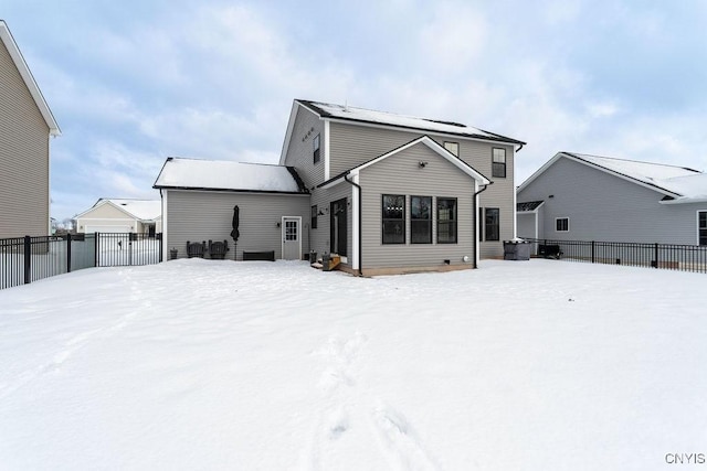 snow covered house with fence