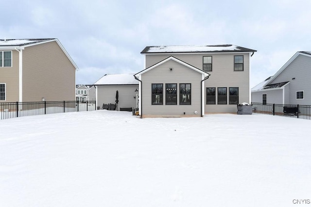 snow covered house with fence