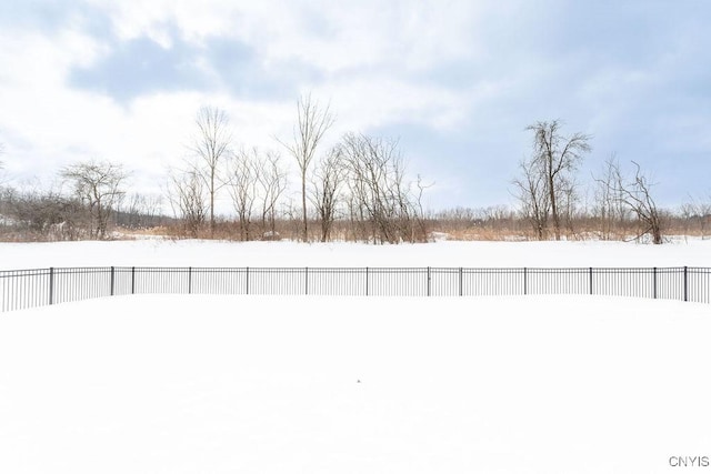 yard covered in snow with a fenced backyard