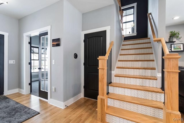 staircase featuring wood finished floors and baseboards