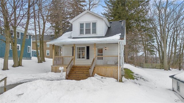 bungalow with a porch, stairway, and a garage