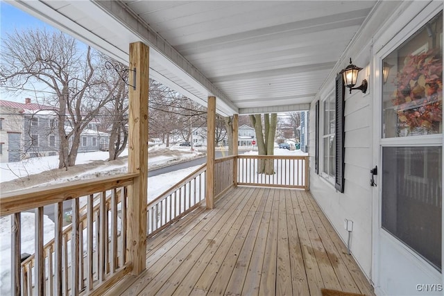 snow covered deck with a porch