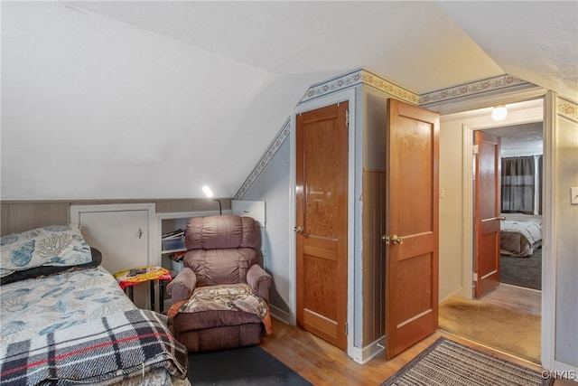 bedroom featuring light wood-style floors and vaulted ceiling