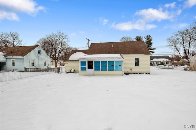 snow covered house with fence