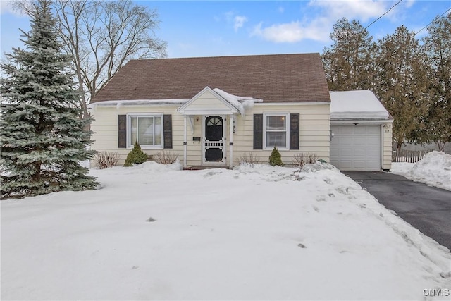 view of front of property with aphalt driveway, roof with shingles, and an attached garage