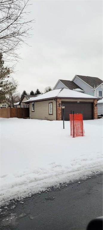 view of front of property with a garage and fence