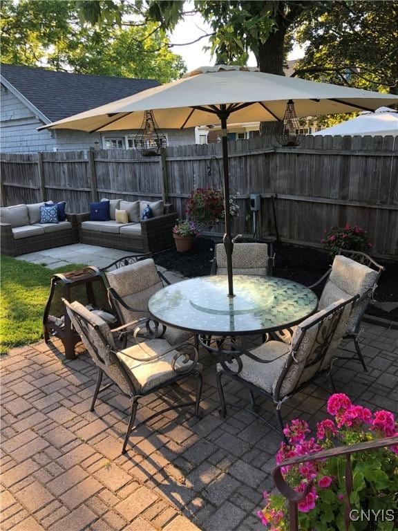 view of patio / terrace with outdoor dining area, a fenced backyard, and an outdoor living space