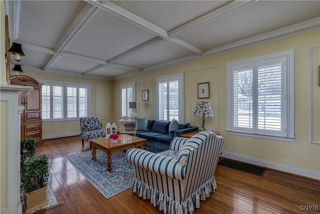 living area with coffered ceiling, a healthy amount of sunlight, visible vents, and hardwood / wood-style flooring