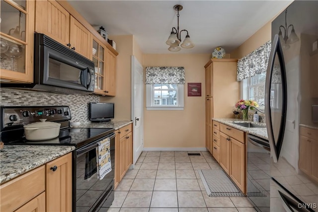 kitchen with decorative backsplash, glass insert cabinets, light tile patterned flooring, a sink, and black appliances