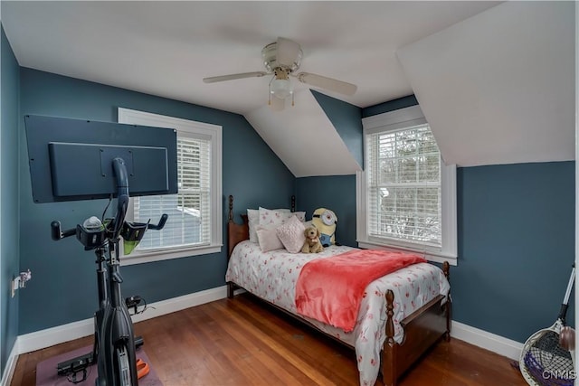 bedroom featuring lofted ceiling, baseboards, and wood finished floors