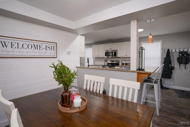 dining room with dark wood-style flooring, visible vents, and baseboards