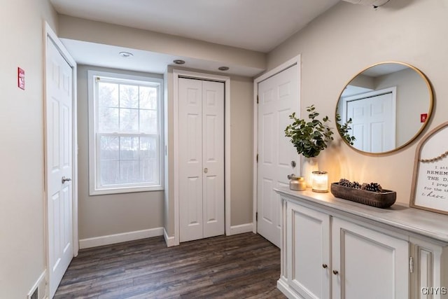 doorway featuring dark wood-type flooring, visible vents, and baseboards