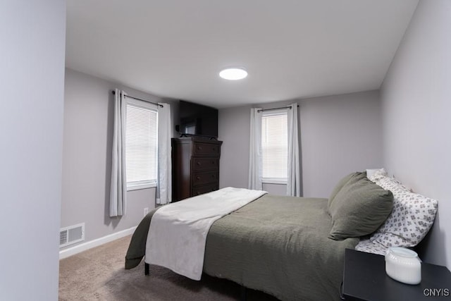 carpeted bedroom with multiple windows, visible vents, and baseboards