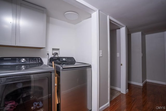 clothes washing area with cabinet space, independent washer and dryer, baseboards, and wood finished floors