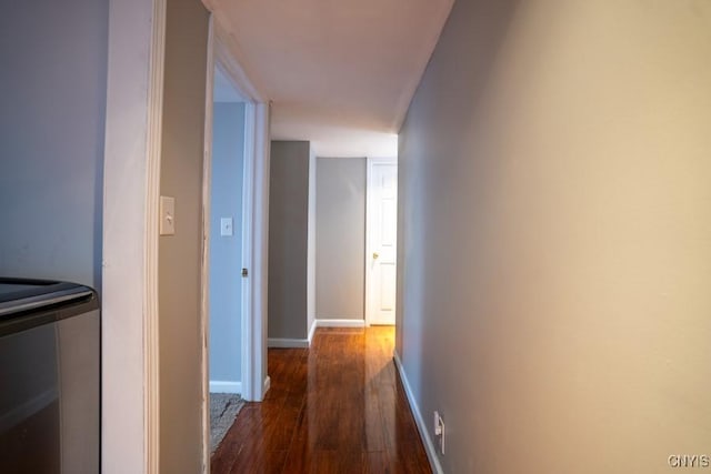 hallway featuring baseboards and wood finished floors