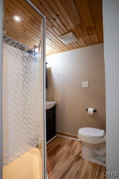 bathroom with visible vents, toilet, vanity, wood finished floors, and wooden ceiling