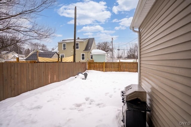 yard covered in snow featuring fence