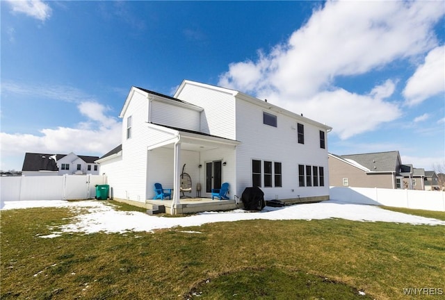 rear view of house with a patio area, a fenced backyard, and a lawn