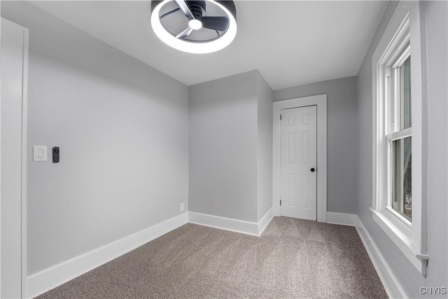 spare room featuring carpet floors, a healthy amount of sunlight, and baseboards