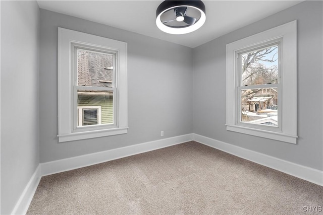 spare room featuring carpet and baseboards