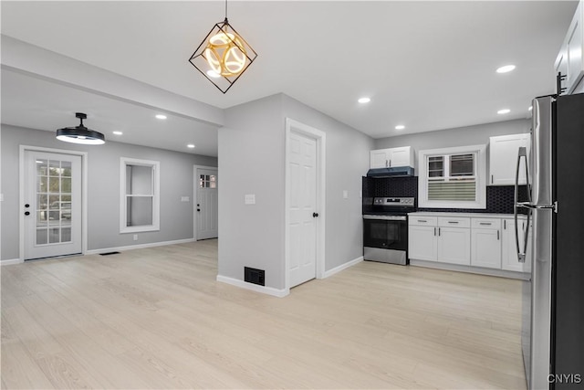 kitchen with appliances with stainless steel finishes, light wood-type flooring, white cabinetry, and under cabinet range hood