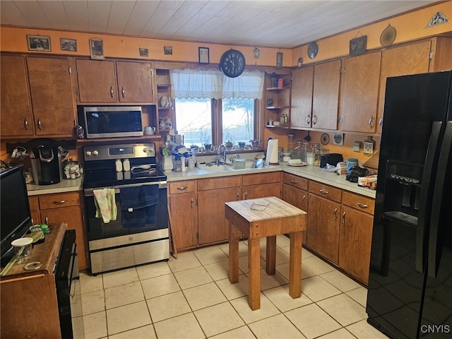 kitchen with light tile patterned floors, stainless steel appliances, light countertops, open shelves, and a sink