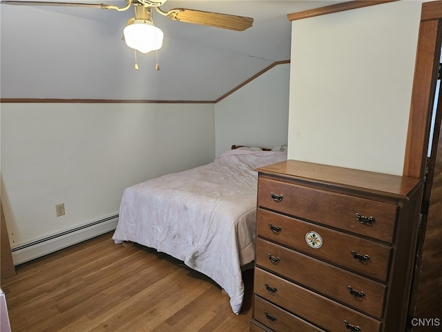 bedroom featuring a baseboard heating unit, vaulted ceiling, ceiling fan, and wood finished floors