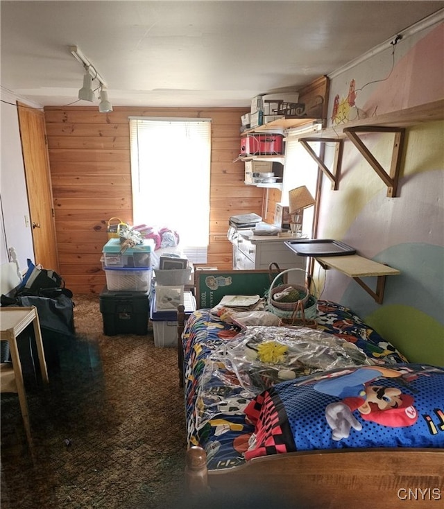 carpeted bedroom featuring wood walls