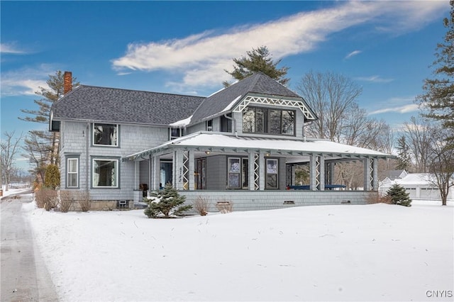 victorian home featuring a shingled roof and a chimney