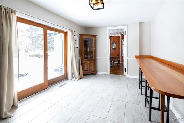 unfurnished dining area featuring visible vents and baseboards